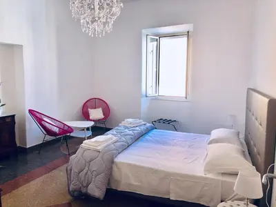 a bedroom with a large bed and a chandelier at S.Apollonia Suite Trastevere in Rome