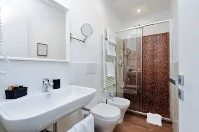 a white bathroom with a sink and a toilet at Victory Rooms in Rome