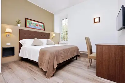 a bedroom with a bed and a desk and a television at Victory Rooms in Rome