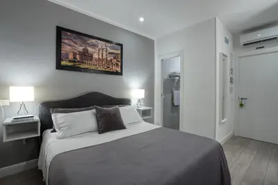 a bedroom with a bed and a painting on the wall at Rhome Guest House in Rome