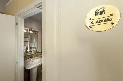 a bathroom with a sink and a sign on the door at Dimora Degli Dei in Rome