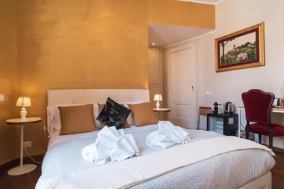 a bedroom with a large bed with towels on it at Golden Rooms Piazza di Spagna in Rome