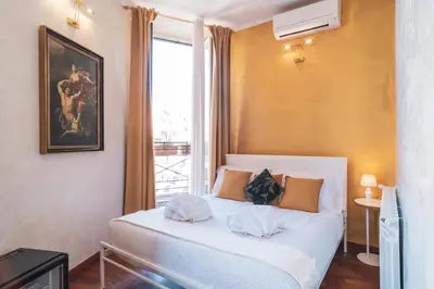 a bedroom with a white bed and a window at Golden Rooms Piazza di Spagna in Rome