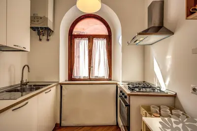 a kitchen with an arched window and a sink at Campo di Fiori 2 bedroom Via Giulia in Rome