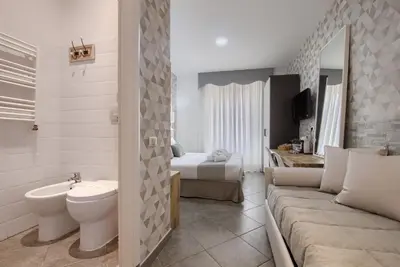 a bathroom with a couch and a toilet and a bed at Vatican Treasure in Rome