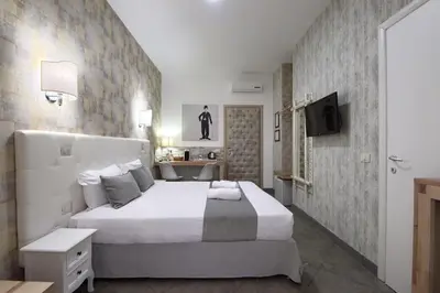 a bedroom with a large white bed and a tv at Vatican Treasure in Rome