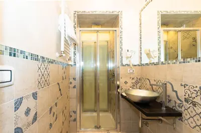 a bathroom with a sink and a glass shower at Roma Charming Rooms in Rome