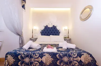 a bedroom with a bed with a blue and white bedspread at Roma Charming Rooms in Rome