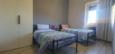a bedroom with two beds and a window at Hello Roma B&B in Rome
