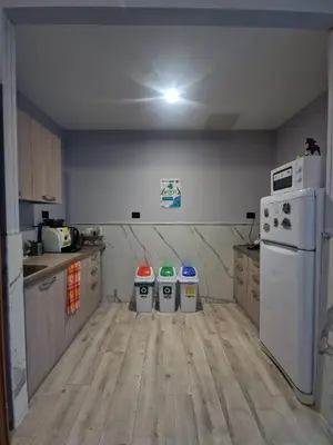 a kitchen with three trash cans and a refrigerator at Hello Roma B&B in Rome