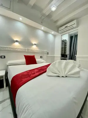 a bedroom with a large white bed with a red pillow at Locanda Parlamento in Rome