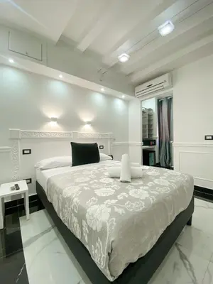 a white bedroom with a large bed and a table at Locanda Parlamento in Rome