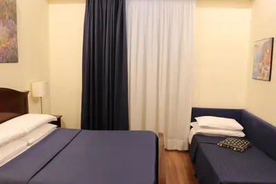 a hotel room with two beds and a window at The Center Of Rome B&B in Rome