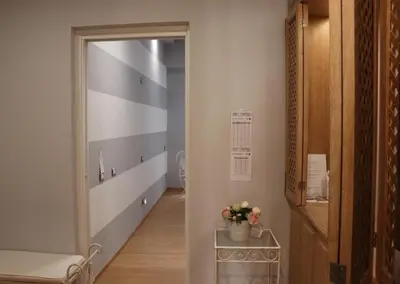 a hallway with a mirror and a chair and a table at The Center Of Rome B&B in Rome