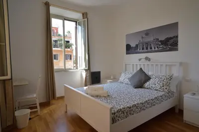a white bedroom with a bed and a window at Livia B&B - Trastevere in Rome