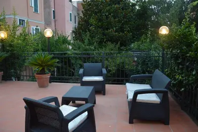 a patio with chairs and tables and a fence at L'Oasi al Pigneto - Guest house in Rome