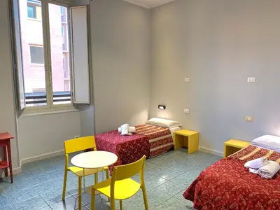 a room with two beds and a table and chairs at Residenza Giustiniani in Rome