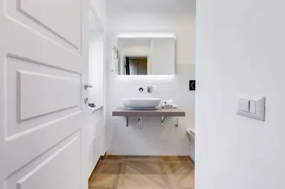 a white bathroom with a sink and a mirror at Mellini Palace Suites by Premium Suites Collection in Rome
