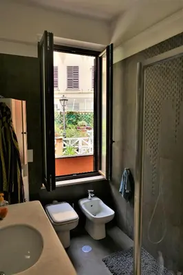 a bathroom with a toilet and a sink and a window at La Casa nel Borgo in Rome