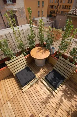 a patio with two benches and a table on a balcony at LOST&FOUND in Trastevere in Rome