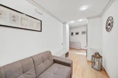 a living room with a couch and a clock on the wall at Peroni 8 Pax Brand New Apartment in Rome