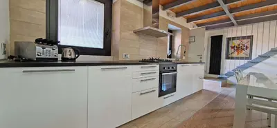a large kitchen with white cabinets and a window at Ponte Milvio Luxury House in Rome