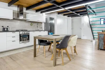 a kitchen with a wooden table and chairs at Ponte Milvio Luxury House in Rome