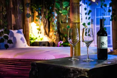 a bottle of wine and two wine glasses on a table at MagicSuite Guest House Roma Portuense in Rome