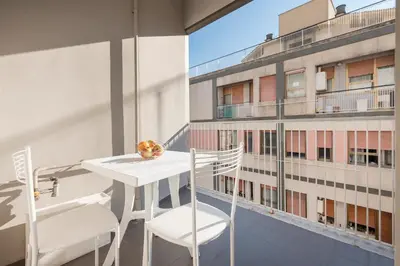 a white table and chairs on a balcony with a building at World Wide Bed San Giovanni in Rome
