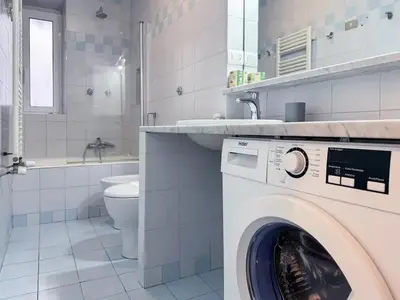 a washing machine in a bathroom with a sink and a toilet at JHHIT San Pietro Modern Suite in Rome