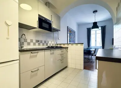 a kitchen with white cabinets and a black counter top at JHHIT San Pietro Modern Suite in Rome