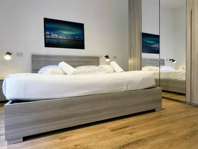 a bedroom with two beds and a large mirror at JHHIT Tuscolana Suite 03 with Terrace in Rome