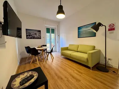a living room with a green couch and a table at JHHIT Tuscolana Suite 03 with Terrace in Rome