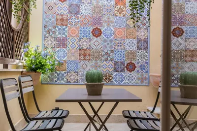 a table and chairs in front of a wall with a quilt at Downtown_Blossom with small terrace in Rome