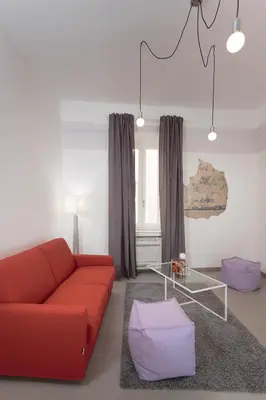 a living room with a red couch and a glass table at Margana Tower in Rome