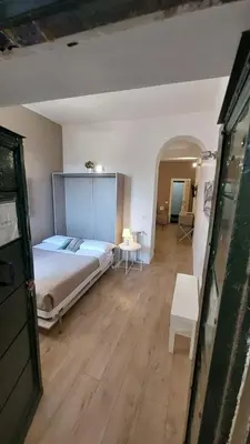a bedroom with a bed and a table and a room at Petit Bijou de Rome Vatican-Trastevere in Rome