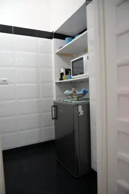 a small refrigerator in a room with a microwave at Petit Bijou de Rome Vatican-Trastevere in Rome