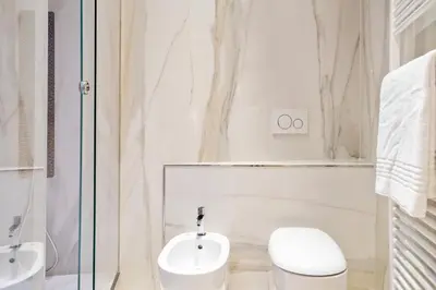 a white bathroom with a toilet and a sink at Pantheon Escape in Rome