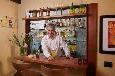 a man standing behind a counter in a bar at Palm Gallery Hotel in Rome