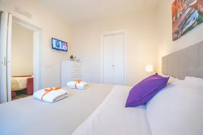 a bedroom with a white bed with two pillows on it at San Peter Lory's Aparts in Rome