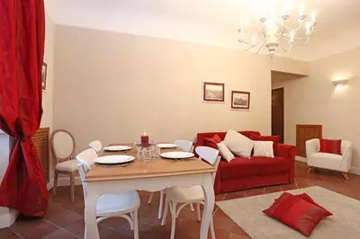 a living room with a table and a red couch at Daplace - Gaia Apartment in Rome