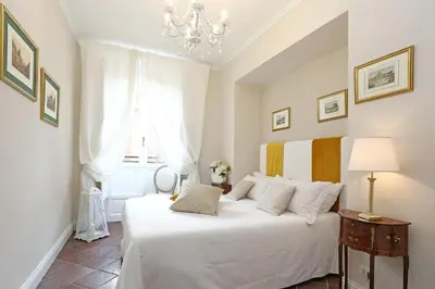 a bedroom with a white bed and a chandelier at Daplace - Gaia Apartment in Rome