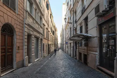an alley with buildings and a person walking down the street at Avignonesi 04 - FromHometoRome in Rome