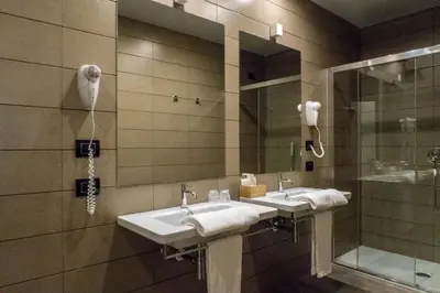 a bathroom with two sinks and a shower at Hotel San Giovanni Roma in Rome
