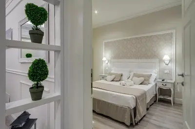 a white bedroom with a bed and a flat screen tv at Charme & Chic Luxury in Rome