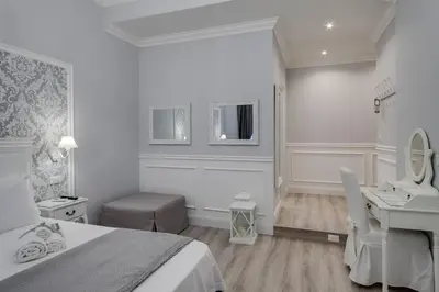 a white bedroom with a large bed and a chair at Charme & Chic Luxury in Rome