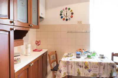 a kitchen with a table and a clock on the wall at Casa Gaby in Rome