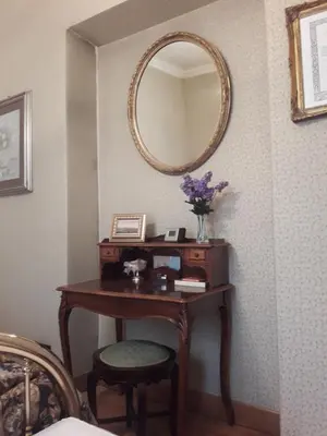 a dressing table with a mirror on a wall at The Queen's Coffer Rome in Rome