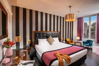 a hotel room with a bed and a desk and chairs at Navona Colors Hotel in Rome