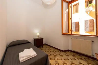 a small bedroom with a bed and a window at Domus Candia in Rome